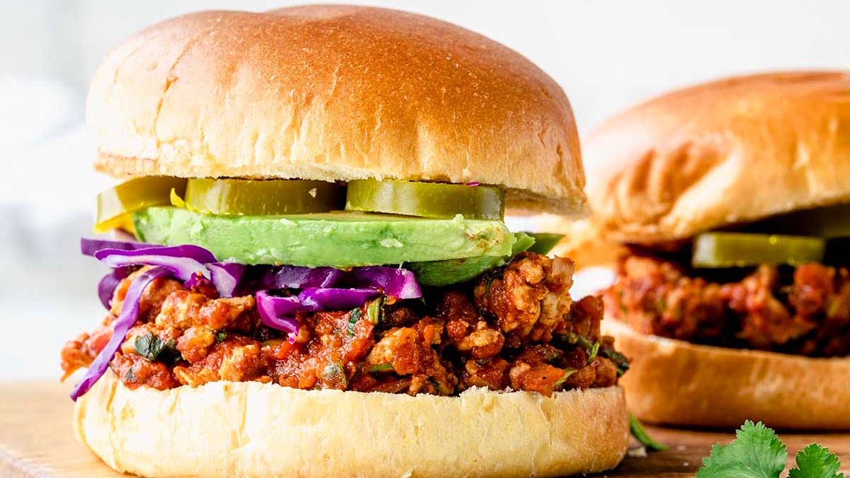 Chicken taco sloppy joe on bun with avocado.