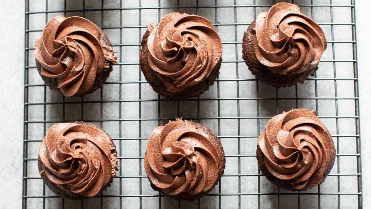 Christmas-themed cupcakes on a cooling rack.