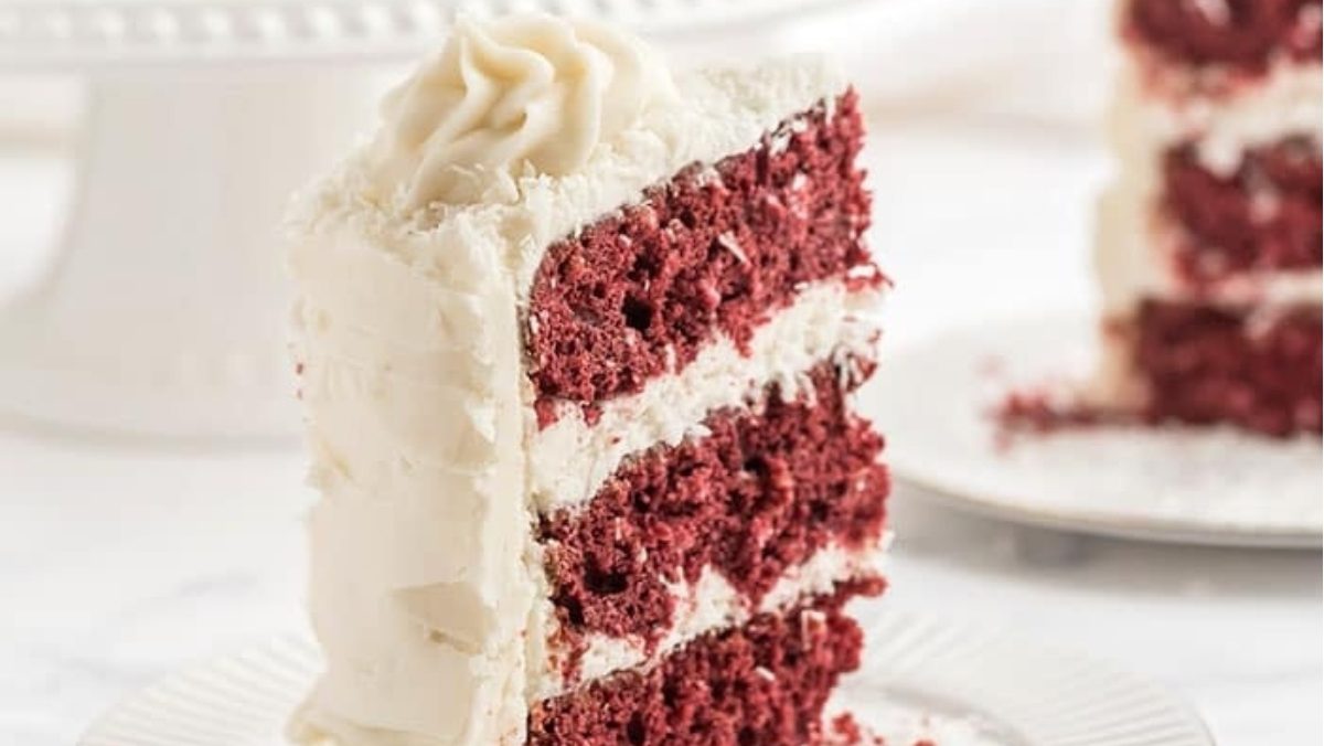 A decadent slice of Red Velvet cake, with its rich crimson hue and moist crumb, beautifully presented on a plate.