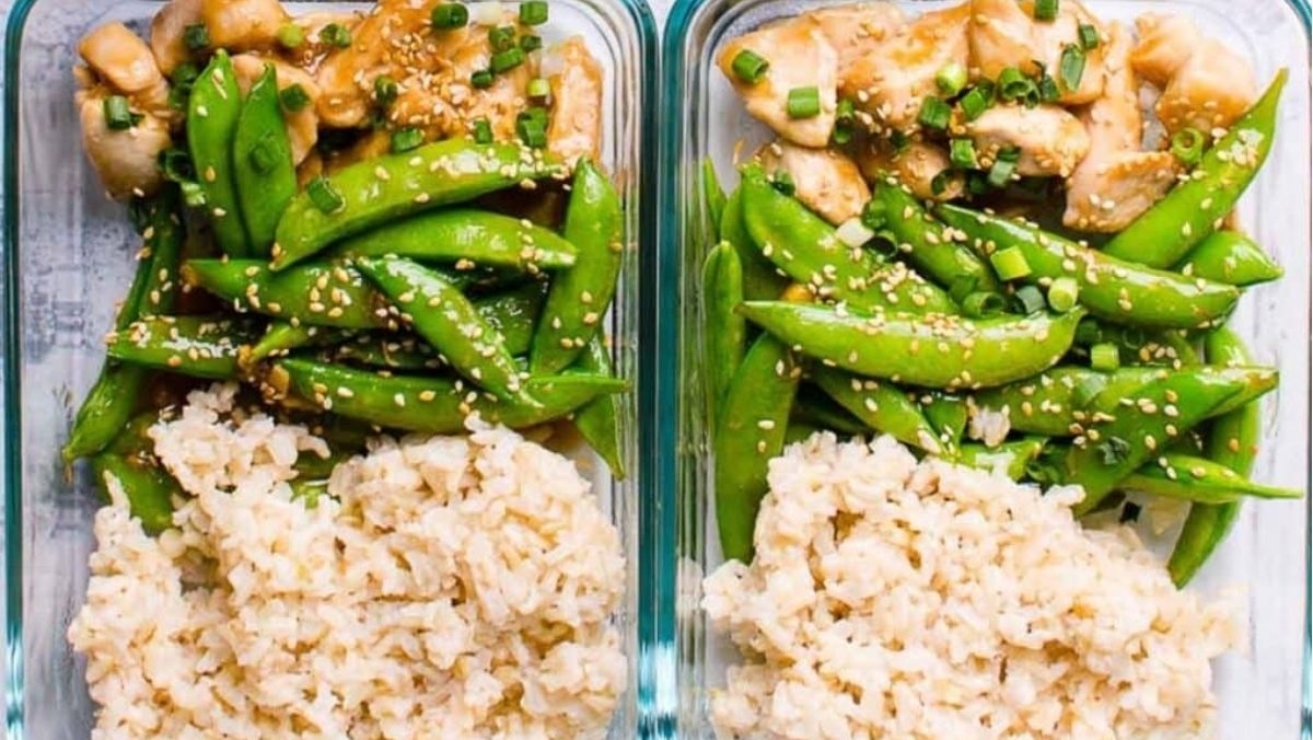 Two glass containers with rice and green peas.