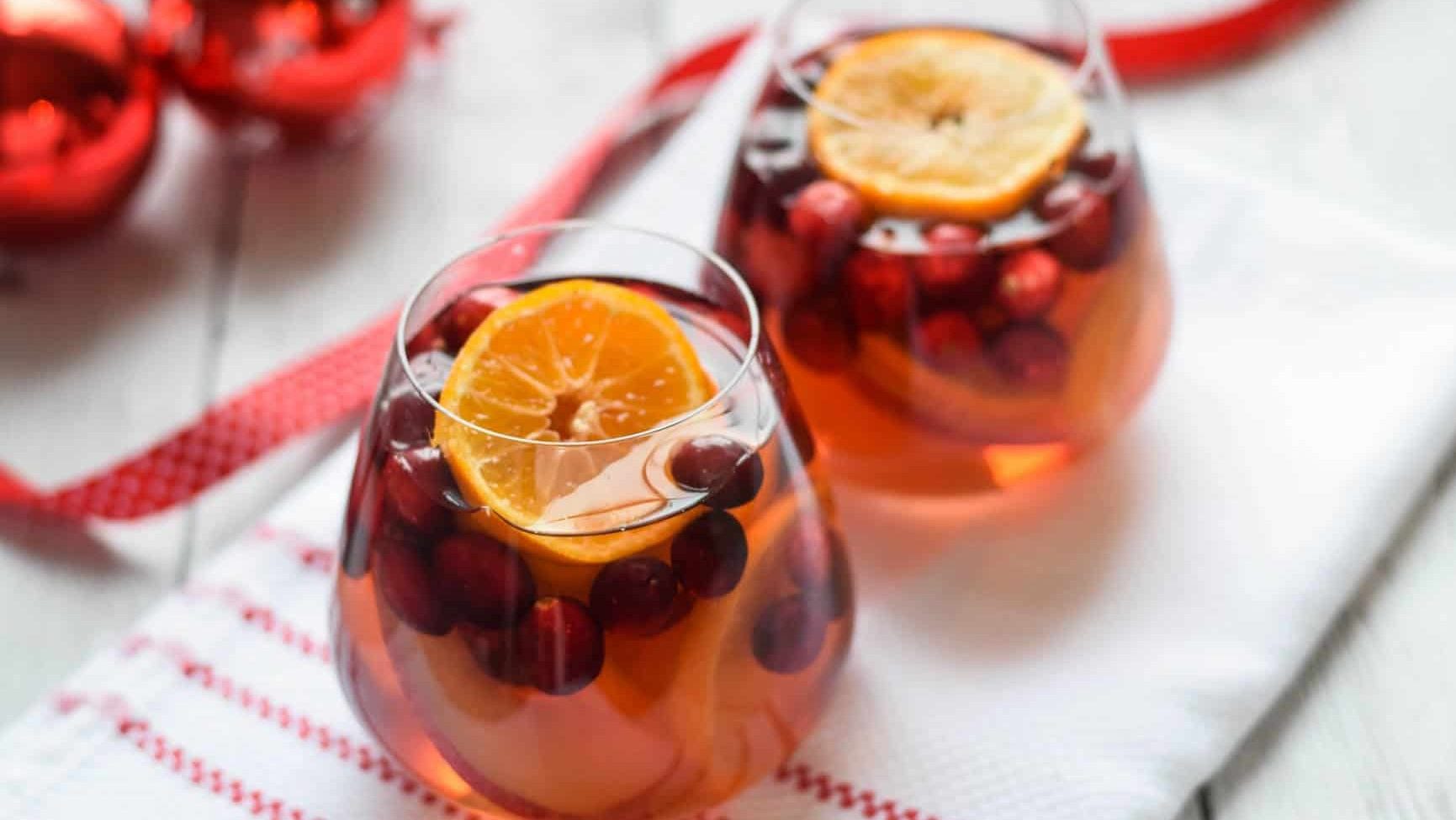 Two glasses of cranberry sangria with orange slices, showcasing a delicious twist on traditional sangria recipes.