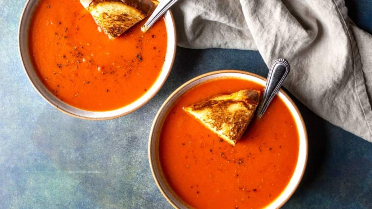 Two bowls of shared tomato soup with toasted bread.