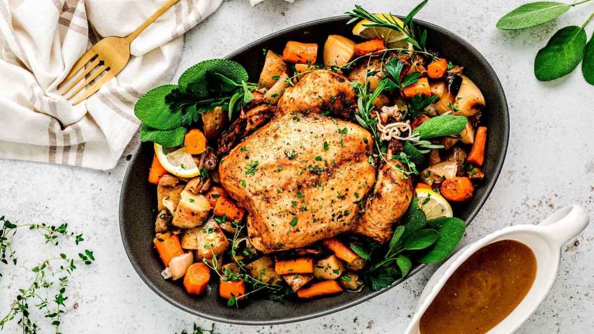Slow cooker roasted chicken with vegetables and gravy in a skillet.