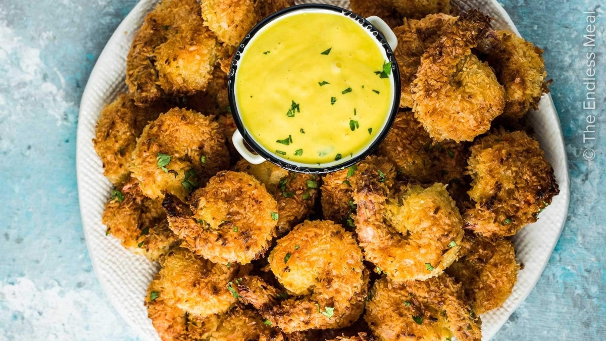 Fried shrimp on a plate with dipping sauce, perfect for a Shrimp Dinner.