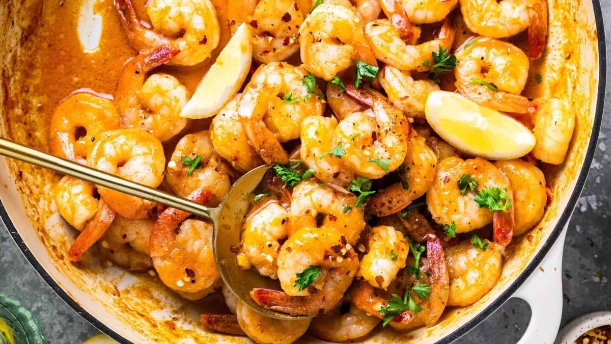 A mouthwatering shrimp dinner dish prepared in a flavorful sauce and cooked in a skillet.